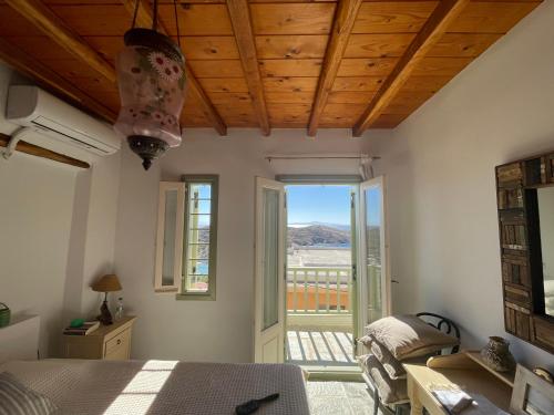 a bedroom with a bed and a view of a balcony at Kalderimi Big Blue Cyclades Syros in Vári