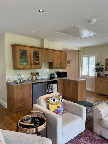 a living room with a couch and a kitchen at Adorable one bedroom apartment with balcony in Newtownards