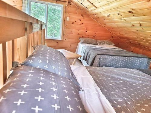 Habitación con 2 camas en una cabaña de madera en Juniper Cabin- Waterfront retreat on Mosque Lake en Ompah