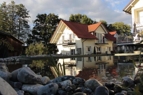 uma casa com um lago em frente em Ferienhof Stärk em Bodnegg