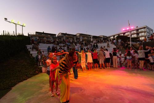 grupa ludzi tańczących przed tłumem w obiekcie Topola Skies Resort & Aquapark w mieście Topola