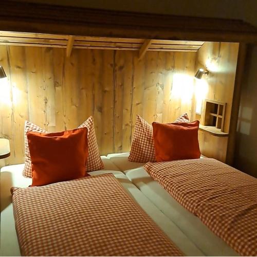 two beds with orange pillows in a room at B&B Talstation Ferienwohnung für 2 Personen in Hörselberg-Hainich