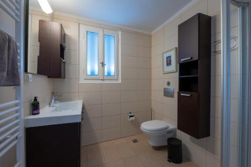 a bathroom with a toilet and a sink at The Mansion - Kalamata Mediterranean Villas in Kalamata