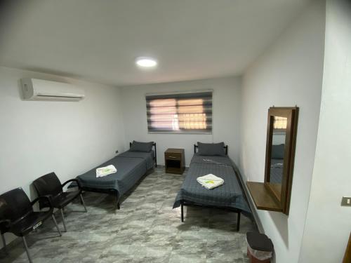 um quarto com uma cama, cadeiras e um espelho em Omar Apartment em Wadi Musa