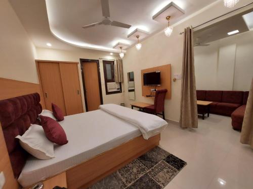 a bedroom with a bed and a living room with a couch at HOTEL KAILASH in Deoria