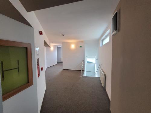 a hallway with white walls and a green painting on the wall at Hotel City Center in Braşov