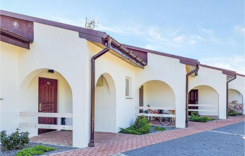 a white building with arches and a red door at Beautiful Home In Slowienkowo in Skrzeszewo