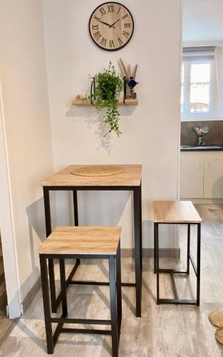 une table et un tabouret avec une horloge sur le mur dans l'établissement L'air Marin - Plage 2min - Hyper Centre - Cosy, au Tréport
