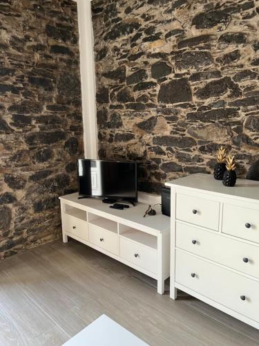 a white dresser with a television on top of it at Casa do Avô in Ponta do Sol