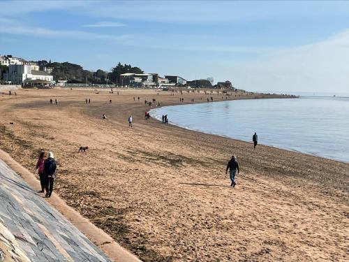 a group of people walking on a beach at Seaview Apartment with parking in Exmouth