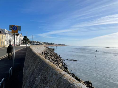 a person riding a bike next to the ocean at Seaview Apartment with parking in Exmouth