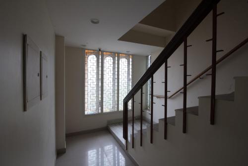 a hallway with stairs and a large window at Arunik Inn in Puducherry