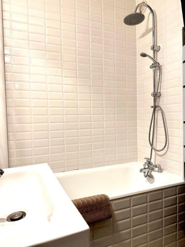 a bathroom with a white tub and a sink at La charmeraie in Compiègne