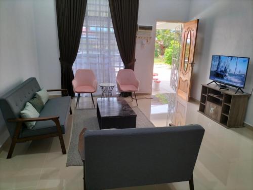 a living room with a couch and chairs and a tv at Wipah Guest House in Kampung Lundang, Kota Bharu in Kota Bharu