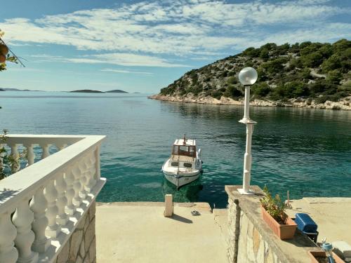 a boat is docked in a body of water at Apartments Uvala Murtar in Jezera