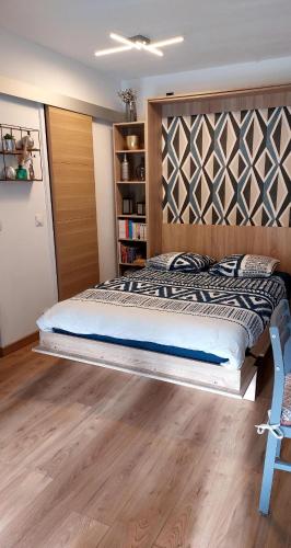 - une chambre avec un grand lit et une tête de lit en bois dans l'établissement Cosy studio le Garden ensoleillé, à Cabourg