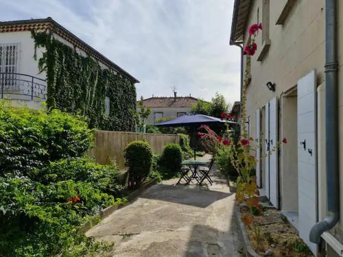 un patio avec une table et des chaises dans une cour dans l'établissement T2 Centre ville avec jardin, à Arles