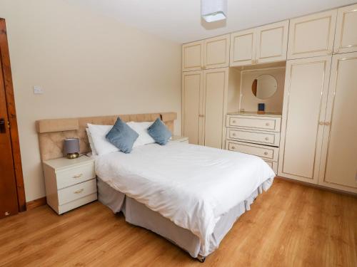 a bedroom with a white bed with blue pillows at Lyreboy in Gortrelig