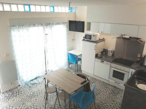 une petite cuisine avec une table et des chaises. dans l'établissement Agréable maison de ville En plein cœur de Rouen, à Rouen