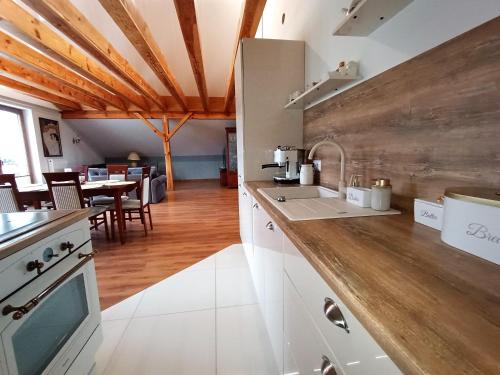 a kitchen with white cabinets and a wooden ceiling at Barytowy apartament in Tarnowskie Góry