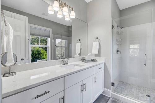 a white bathroom with a sink and a shower at The Darby House in Charleston