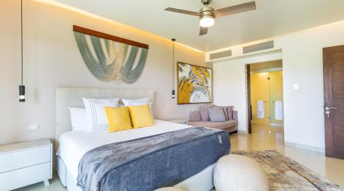 1 dormitorio con 1 cama grande con almohadas amarillas en Casa Brisas apts, en Playa del Carmen