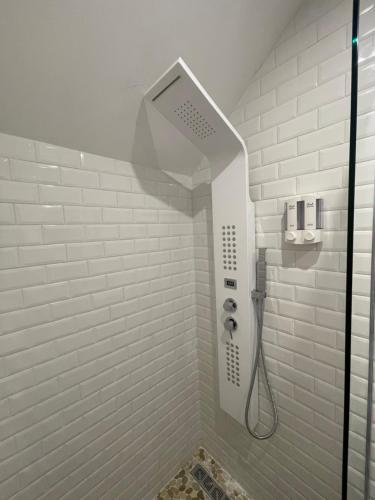 a shower in a bathroom with white tiles at Appartement hors du commun avec son jacuzzi in Salies-de-Béarn