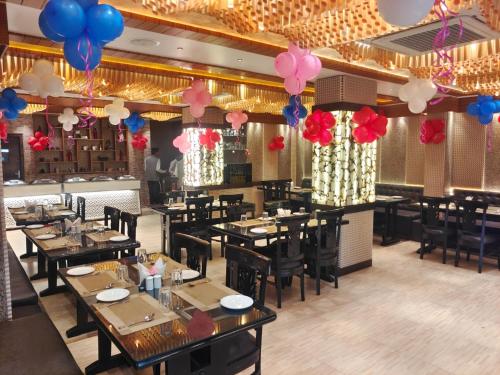 a dining room with tables and balloons on the ceiling at HOTEL ORANGE INN in Patna