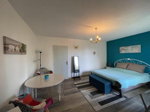 a bedroom with a bed and a table in it at La Colonne in Obernai