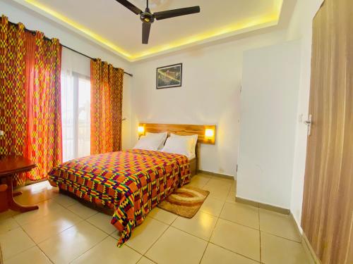 a bedroom with a bed and a large window at GRACE LODGE in Lomé