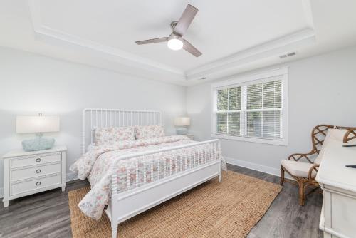 a white bedroom with a bed and a window at LUXURY BEACH HOUSE W/ BACKYARD OASIS. HEATED POOL. in Hilton Head Island