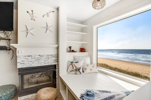 a room with a fireplace and a window with a view of the beach at Sand Castle 2 in Rockaway Beach