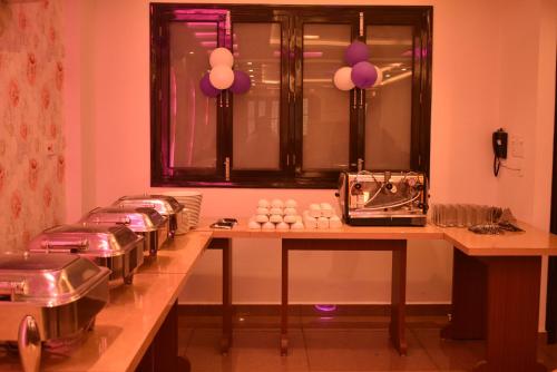 a kitchen with a counter with a bunch of pans at HOTEL KAILASH in Deoria