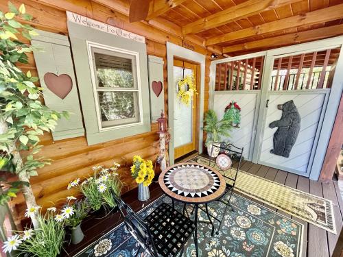 un porche de una cabaña con mesa y sillas en Snoozers Hollow cabin, en Sevierville