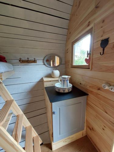 a wooden cabin with a bed and a window at L'authentique Tonneau à Cidre d'Emma in Litteau