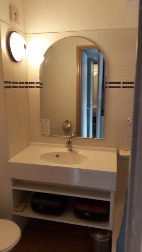 une salle de bain avec un lavabo et un miroir dans l'établissement studio, à Tignes