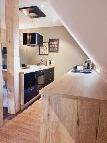 cocina con encimera de madera y escalera en Ferienwohnung Rehblick Spreewaldferien-Burg en Burg (Spreewald)