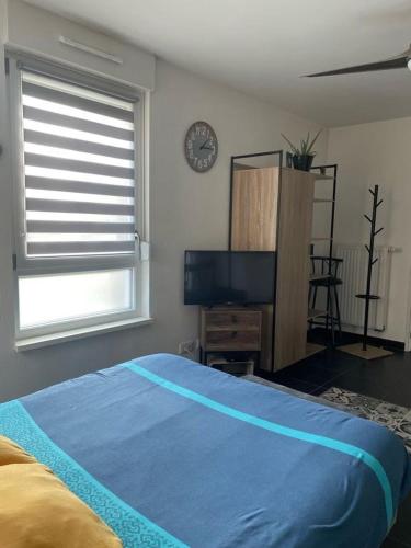 une chambre avec un lit bleu et une télévision à écran plat dans l'établissement Le Beffroi, à Obernai