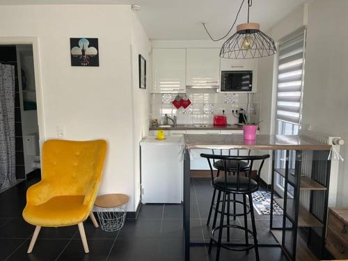 una cocina con una mesa y una silla amarilla. en Le Beffroi, en Obernai