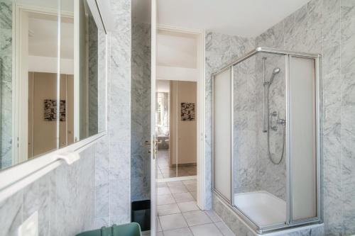 bagno con doccia e porta in vetro di Evia Apartment - bright three-room apartment with lake view a Vernate