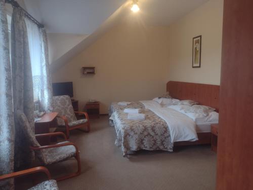 um quarto de hotel com uma cama e uma cadeira em MOTEL ZADOIL *** em Maków Podhalański