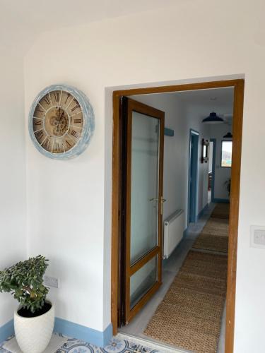 a clock on a wall next to a hallway at Blue Pearl Apartment in Downings