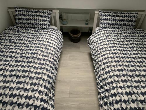 two beds sitting next to each other in a bedroom at Blue Pearl Apartment in Downings