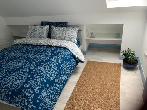 a bedroom with a blue and white bed and a rug at Blue Pearl Apartment in Downings