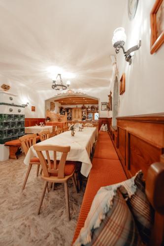a restaurant with a table and chairs and a piano at Dandler - Zimmer und Ferienwohnungen in Fieberbrunn