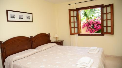 een slaapkamer met een bed en een raam met handdoeken bij Apartamento Heliconia 3 in Valle Gran Rey