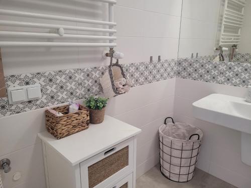 La salle de bains blanche est pourvue d'un lavabo et d'un miroir. dans l'établissement Rezydencja Park Mielno Lake View, à Mielno