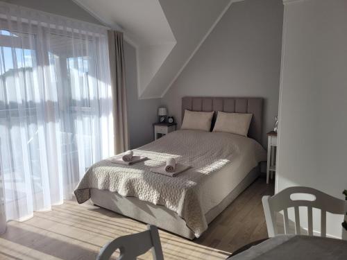 - une chambre avec un lit et une grande fenêtre dans l'établissement Rezydencja Park Mielno Lake View, à Mielno