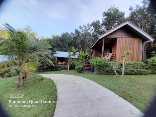 a path leading to a house with a building at Lanta Para hut in Ko Lanta