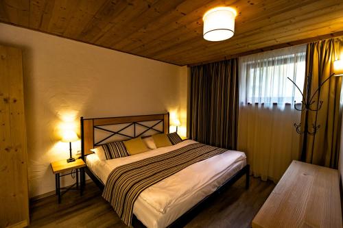 a bedroom with a bed and two lamps and a window at Cardinal Jasna Mountain Wellness Apartment in Belá